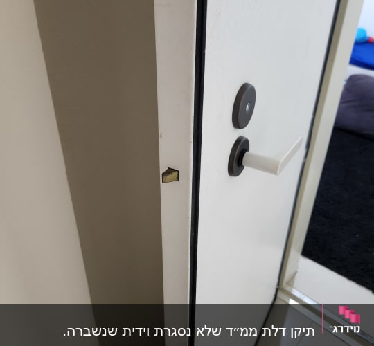 דלת פתוחה עם מנעול וידית לבנה